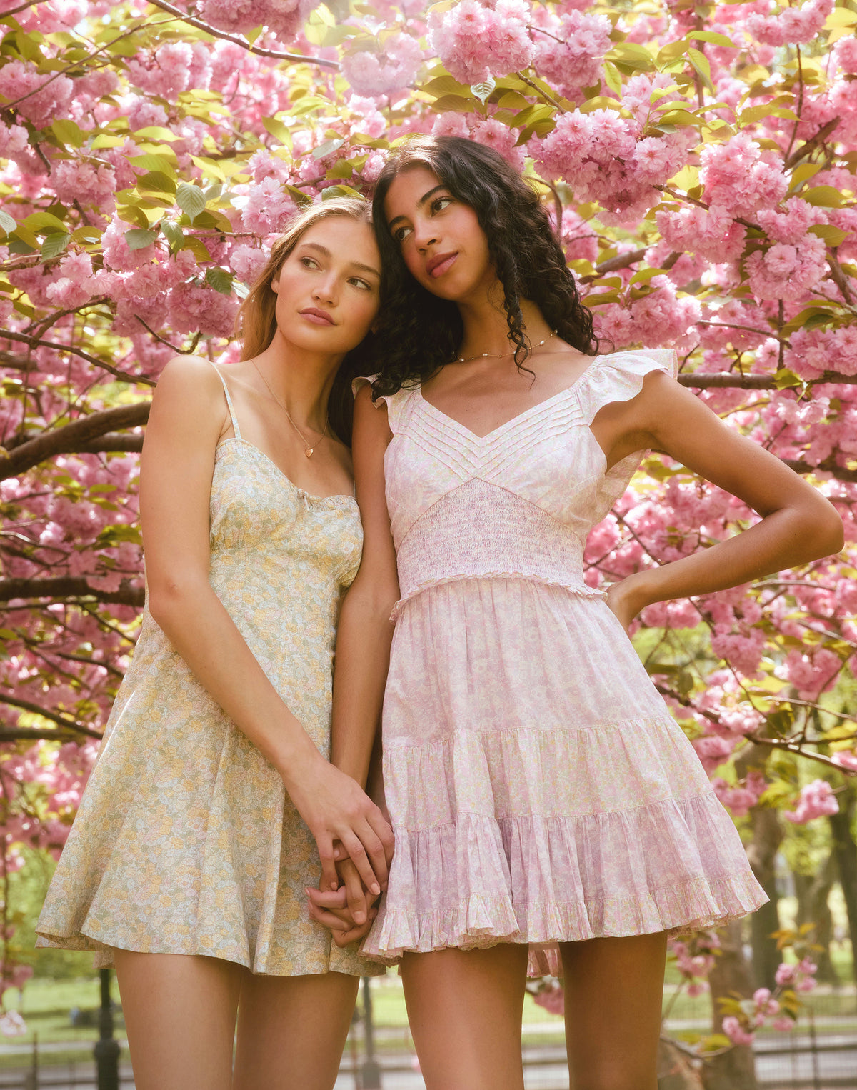 Women sitting in grass field wearing LoveShackFancy Slip Dresses