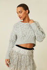 Cable knit sweater with chunky braided neckline and a high-to-low silhouette.