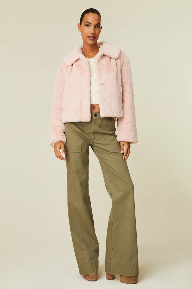 Faux fur jacket features a collar and functional buttons for closure.