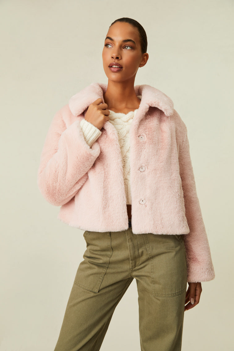 Faux fur jacket features a collar and functional buttons for closure.