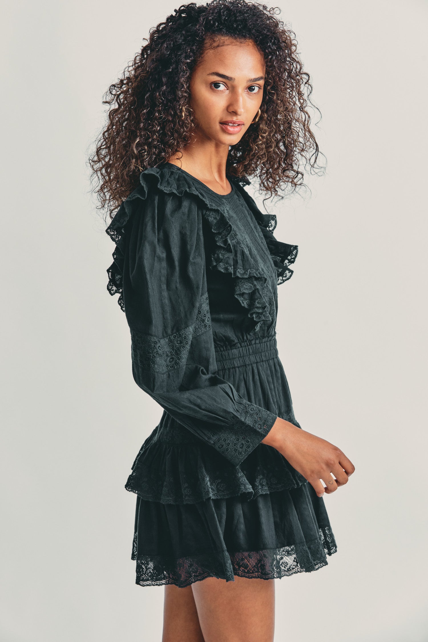 Women's black long sleeve mini dress with lace detail and tapered ruffle princess seam