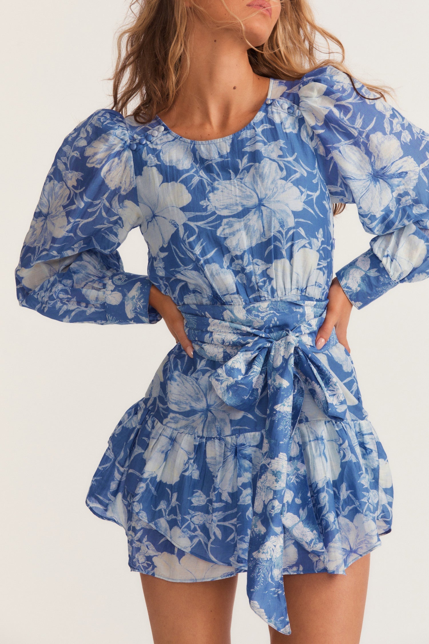 Womens blue floral mini dress with flounce sleeves and sash detail.