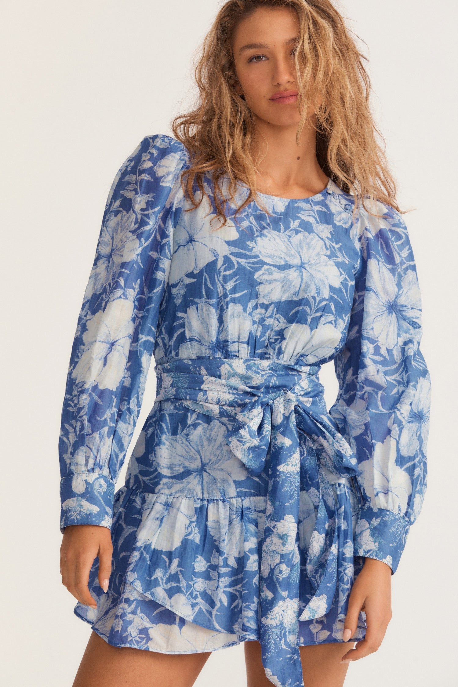 Womens blue floral mini dress with flounce sleeves and sash detail.