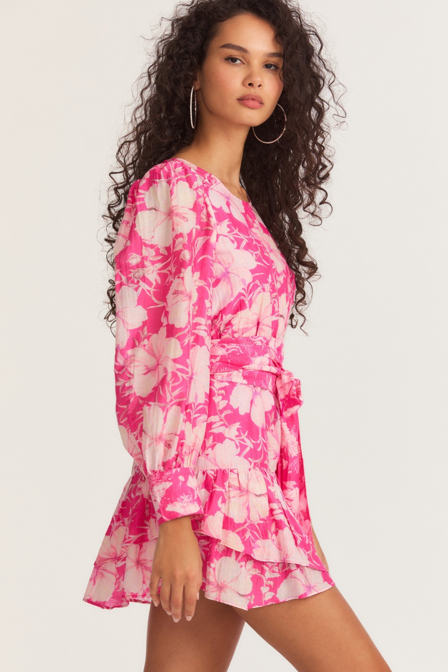 Womens pink floral mini dress with flounce sleeves and sash detail.