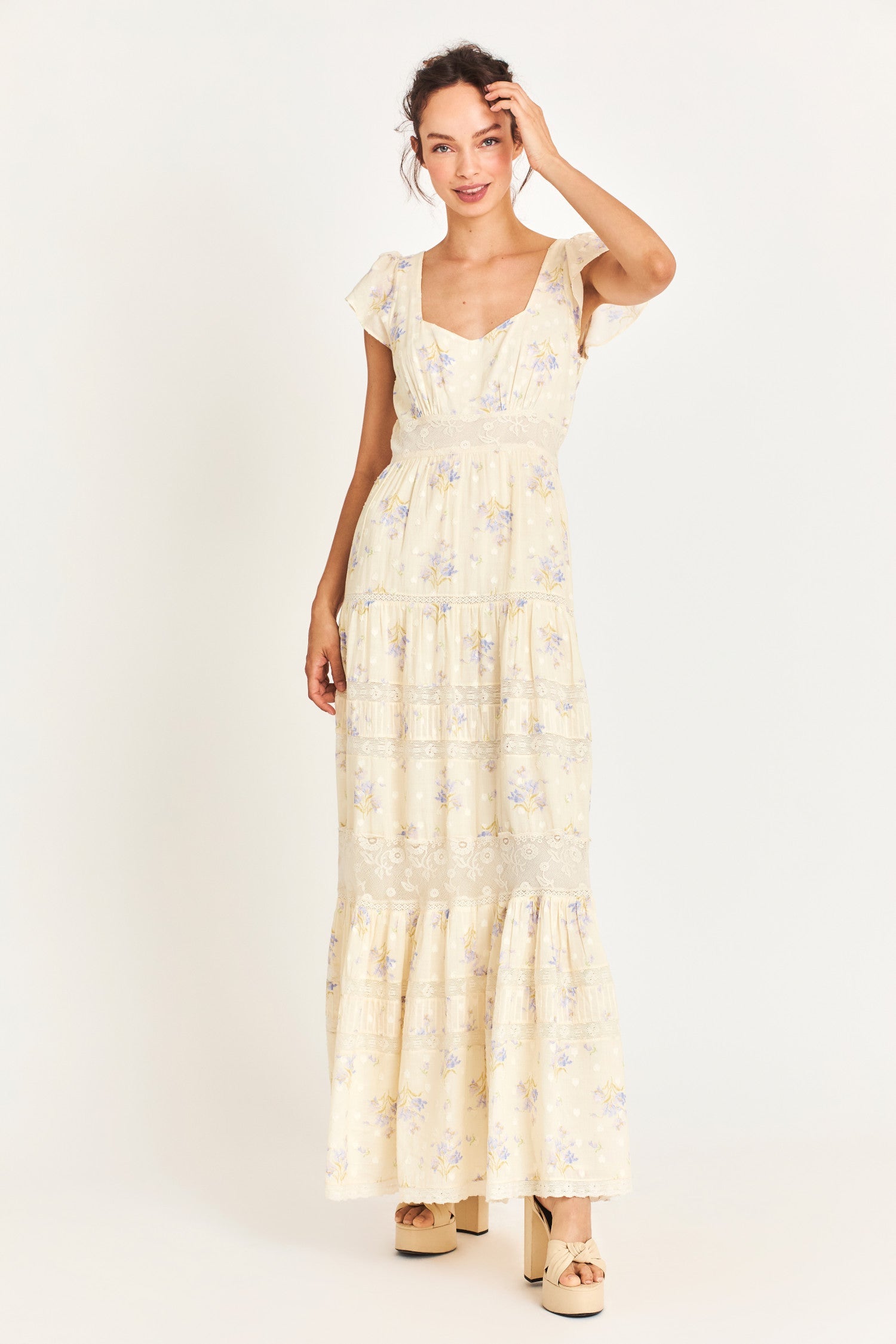 The Melinda Dress is a Victorian-inspired maxi dress in a baby yellow features a textured clip-dotted heart shape lobby fabric cotton and is adorned with a medley of beautiful custom laces. It has sweet flutter sleeves and a flirty open neck. 