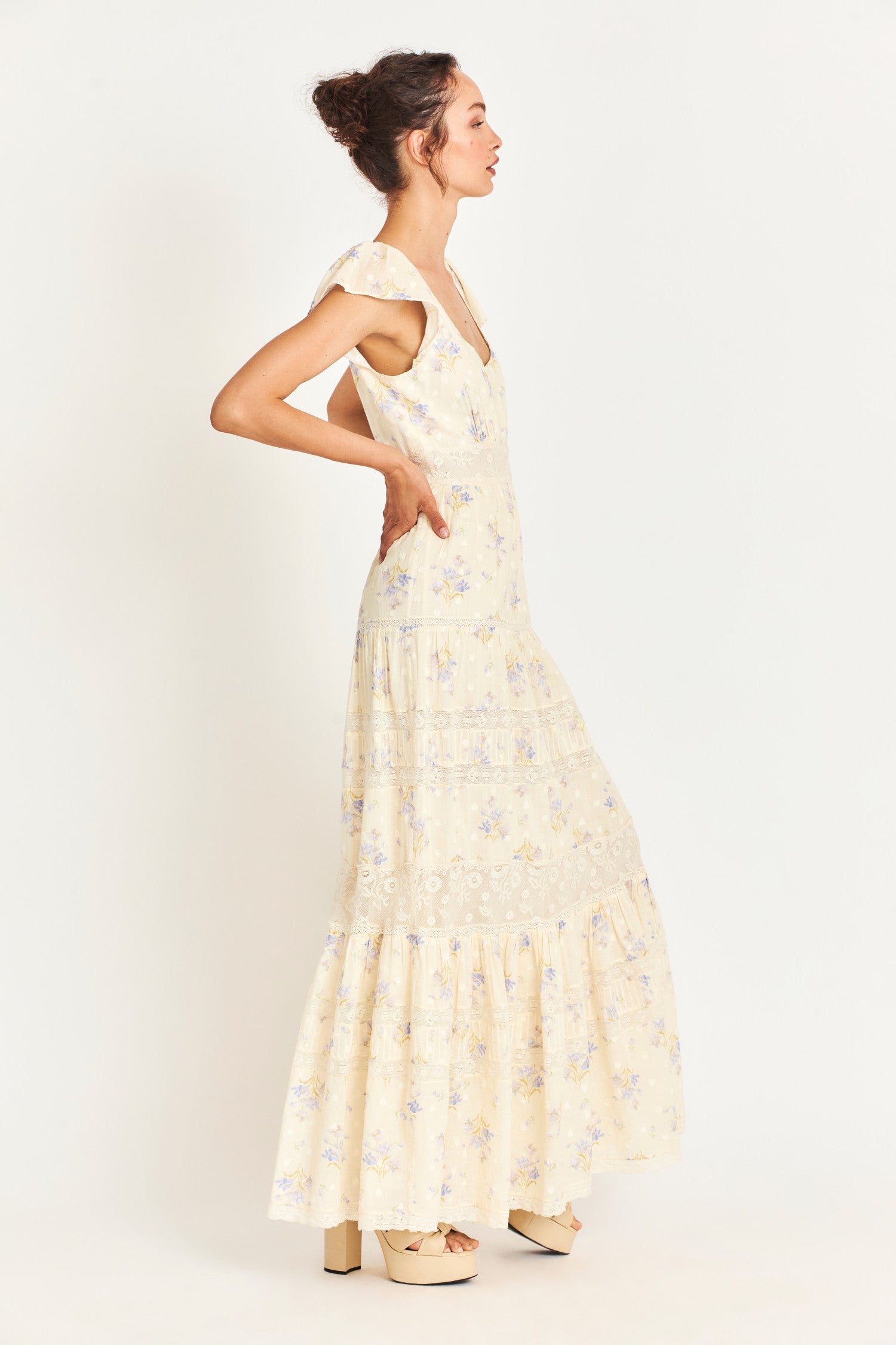 The Melinda Dress is a Victorian-inspired maxi dress in a baby yellow features a textured clip-dotted heart shape lobby fabric cotton and is adorned with a medley of beautiful custom laces. It has sweet flutter sleeves and a flirty open neck. 