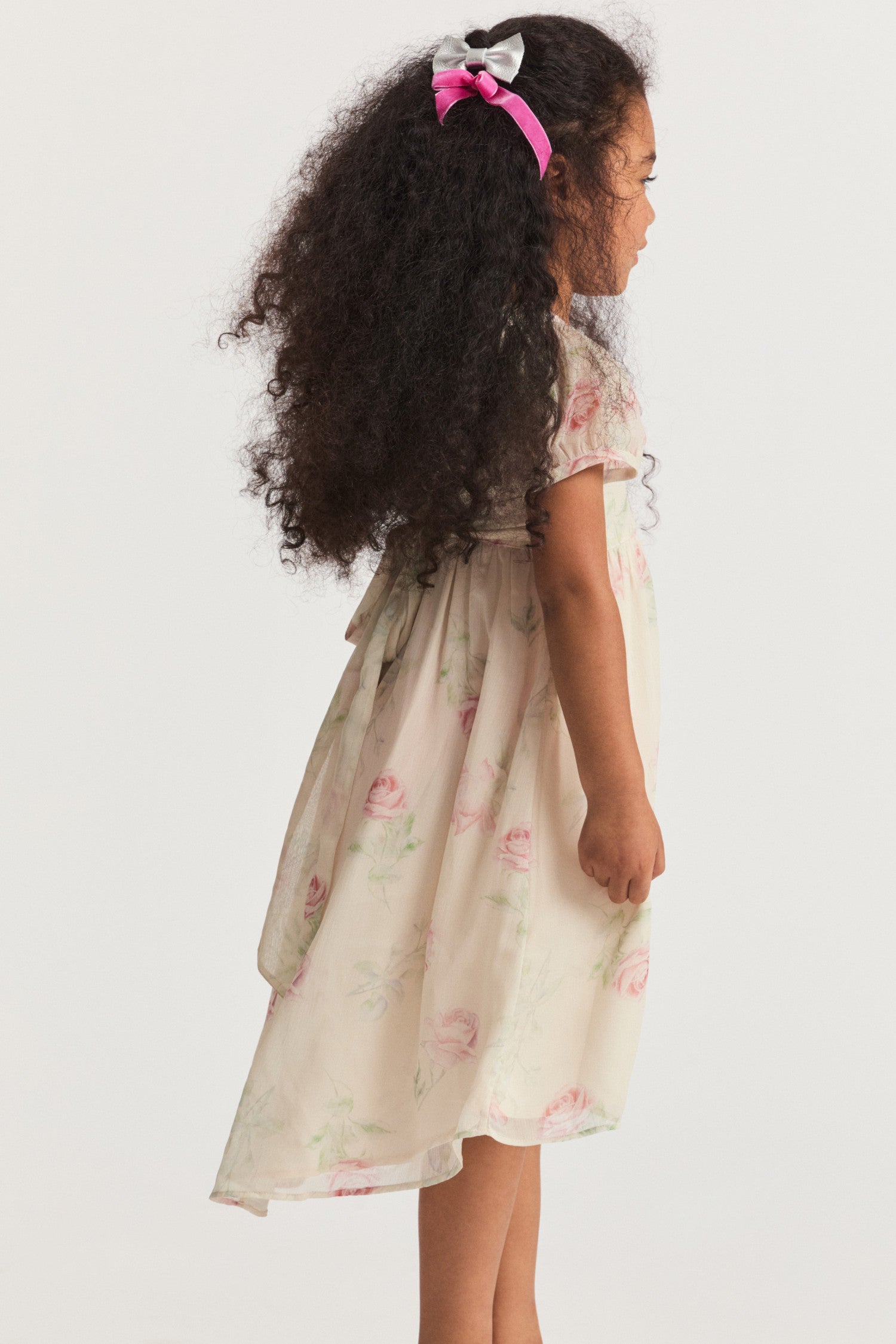 Girls cream floral dress, with sheer puffed sleeves and an empire waist lets down into a full tea-length skirt. Side seam mesh ties extend from the waist to a spirited bow at the back for a sweet touch. Center back button closure.