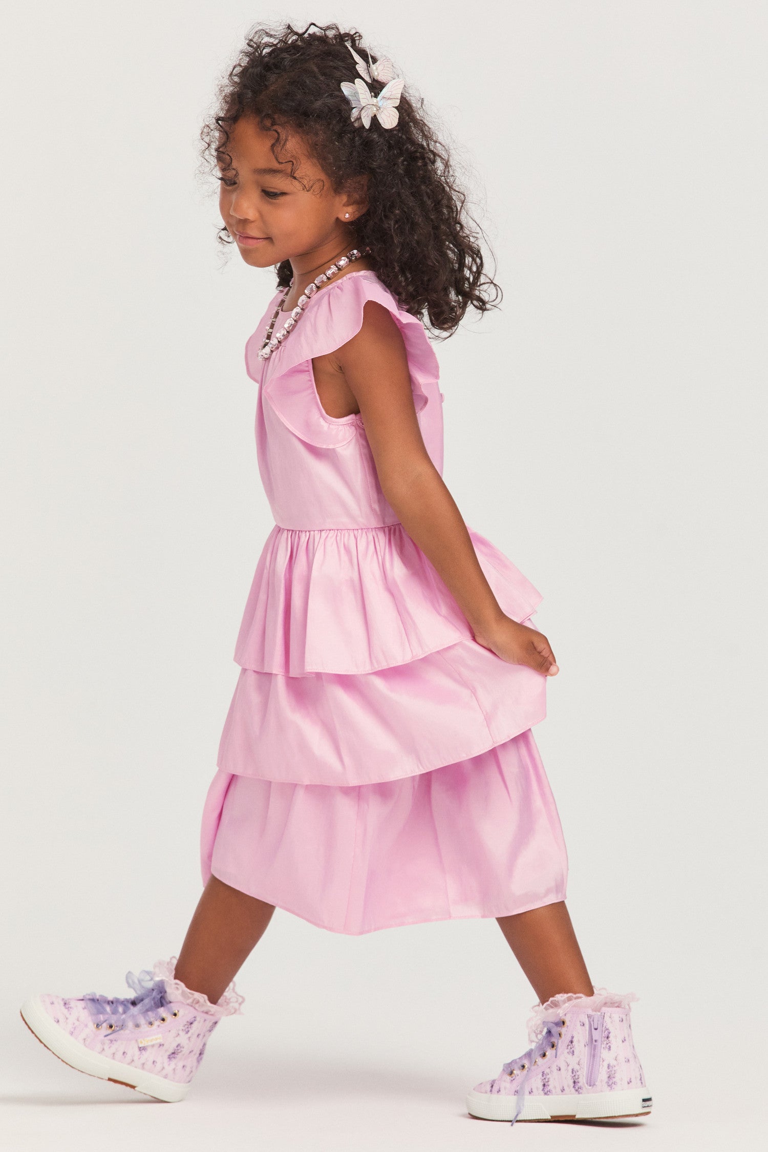 Girls pink dress with nylon fabric, and flutter sleeves frame the roomy bodice. An encased elastic waist lets out into a three-tiered ruffle skirt.