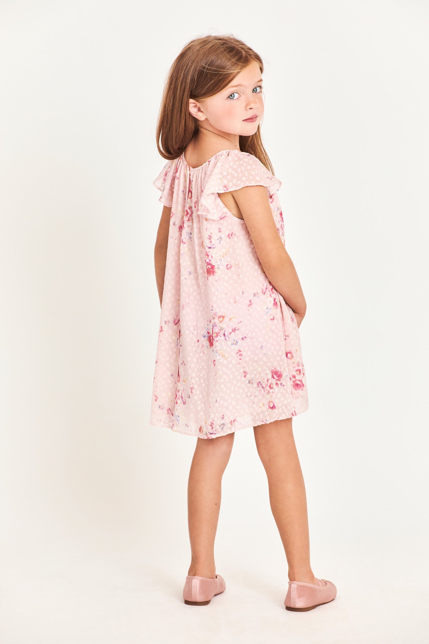 Back image of model wearing kids pink mini dress