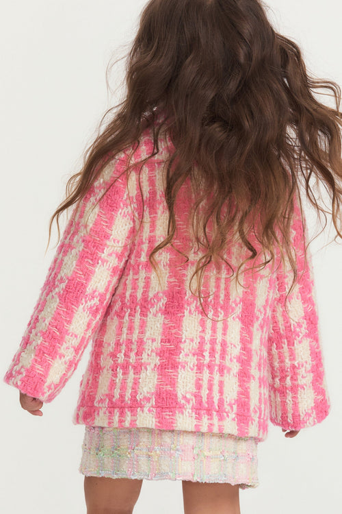 Little girl with pink and white houndstooth print wool jacket with pearl buttons, and pockets.