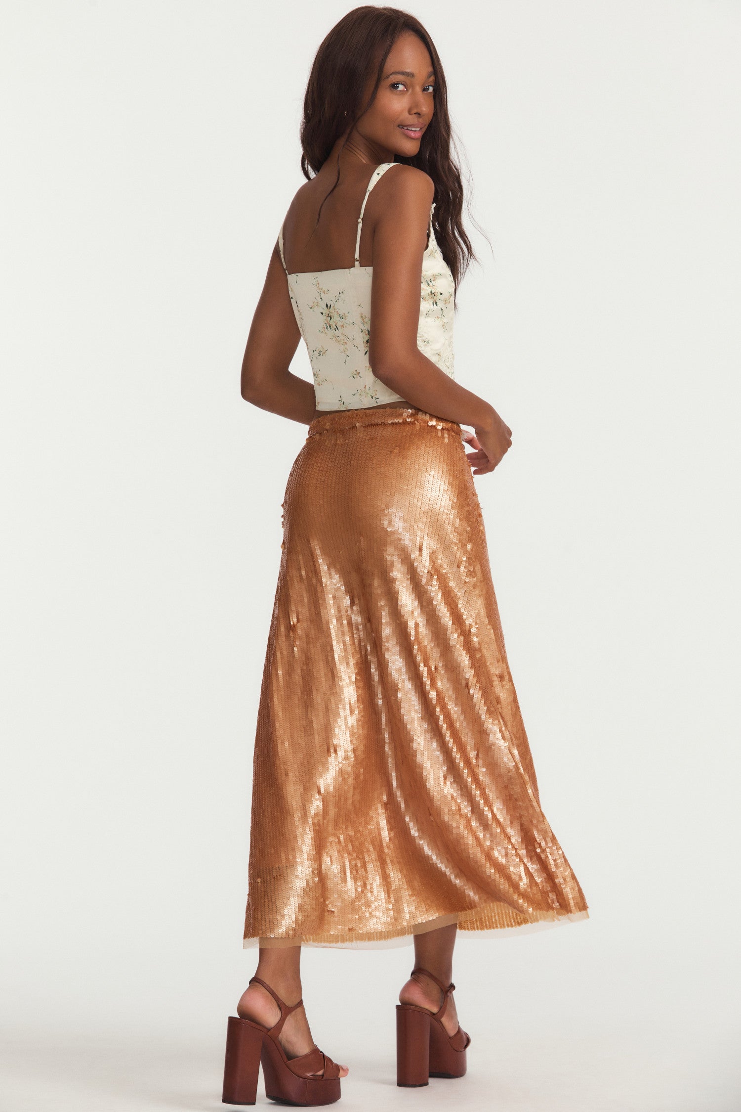 Shimmer golden midi skirt, all-over sequins with a sheer jersey lining that peeks out the bottom, fixed waist, slim fit and invisible zipper at wearer's left.