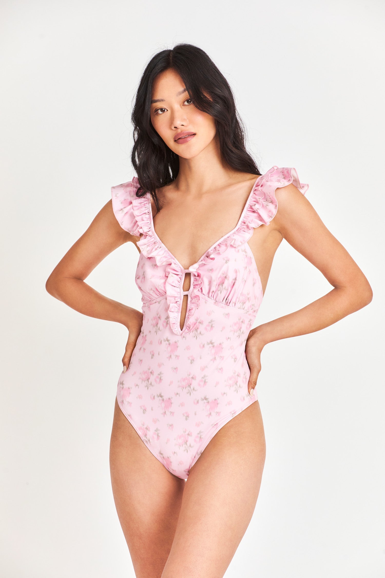 Pink floral one piece swimsuit with ruffle around shoulders/neckline.