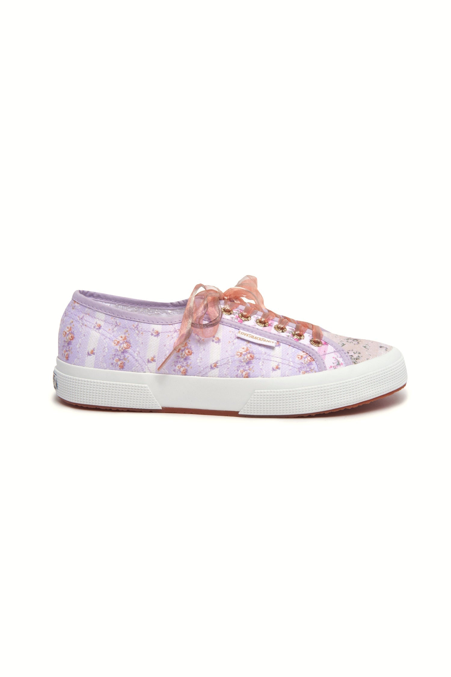 Pastel lilac sneaker with floral pattern on printed cotton, gold-toned eyelet details, and pink organza laces.