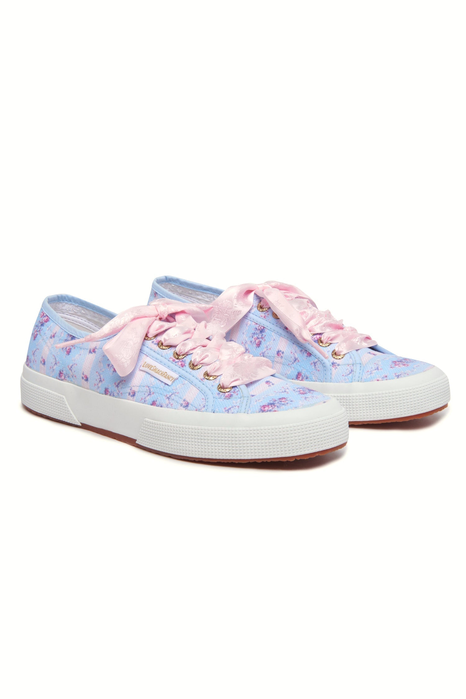 Pastel blue sneaker with floral pattern on printed cotton, gold-toned eyelet details, and pink velvet laces.