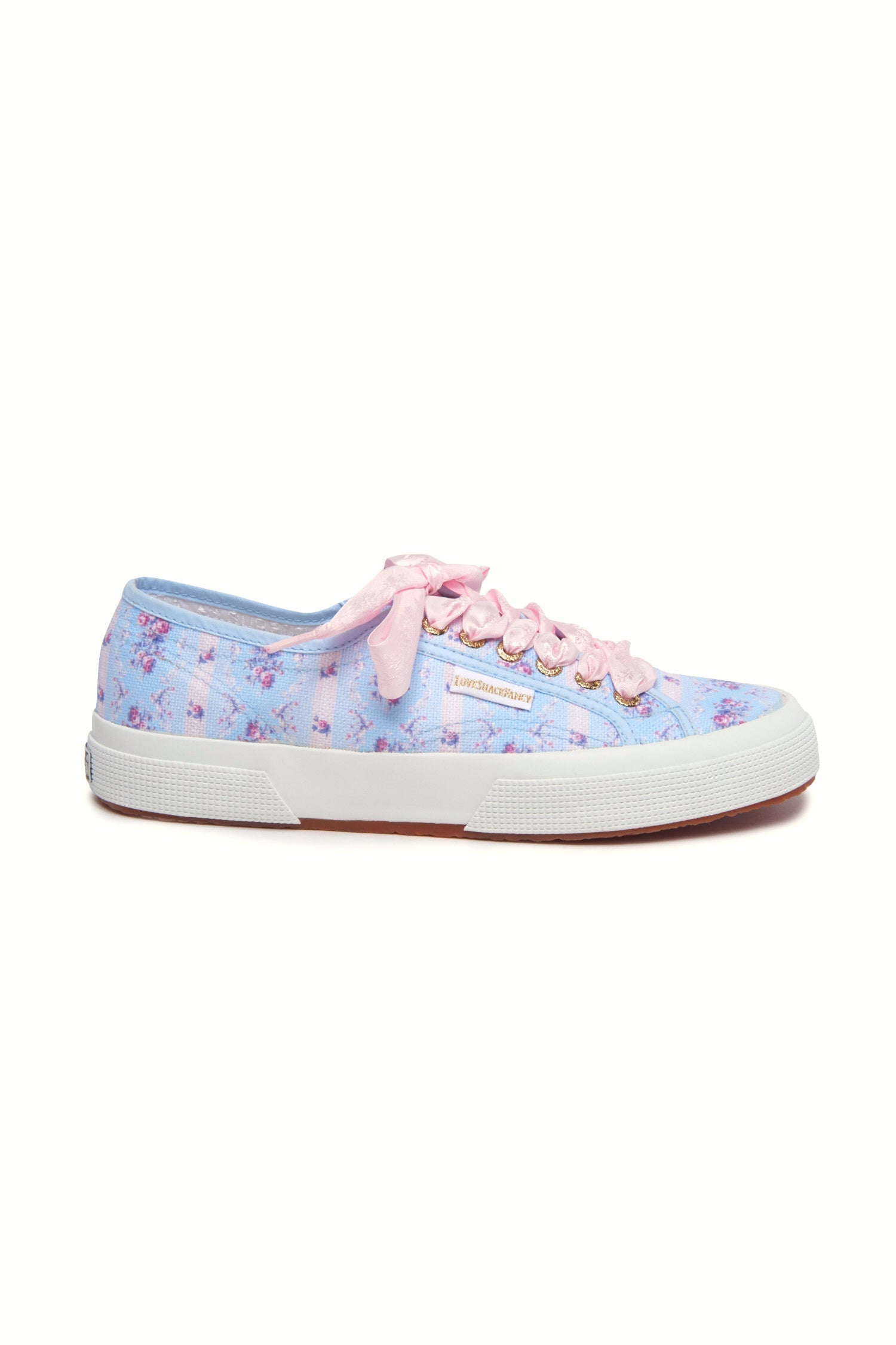 Pastel blue sneaker with floral pattern on printed cotton, gold-toned eyelet details, and pink velvet laces.