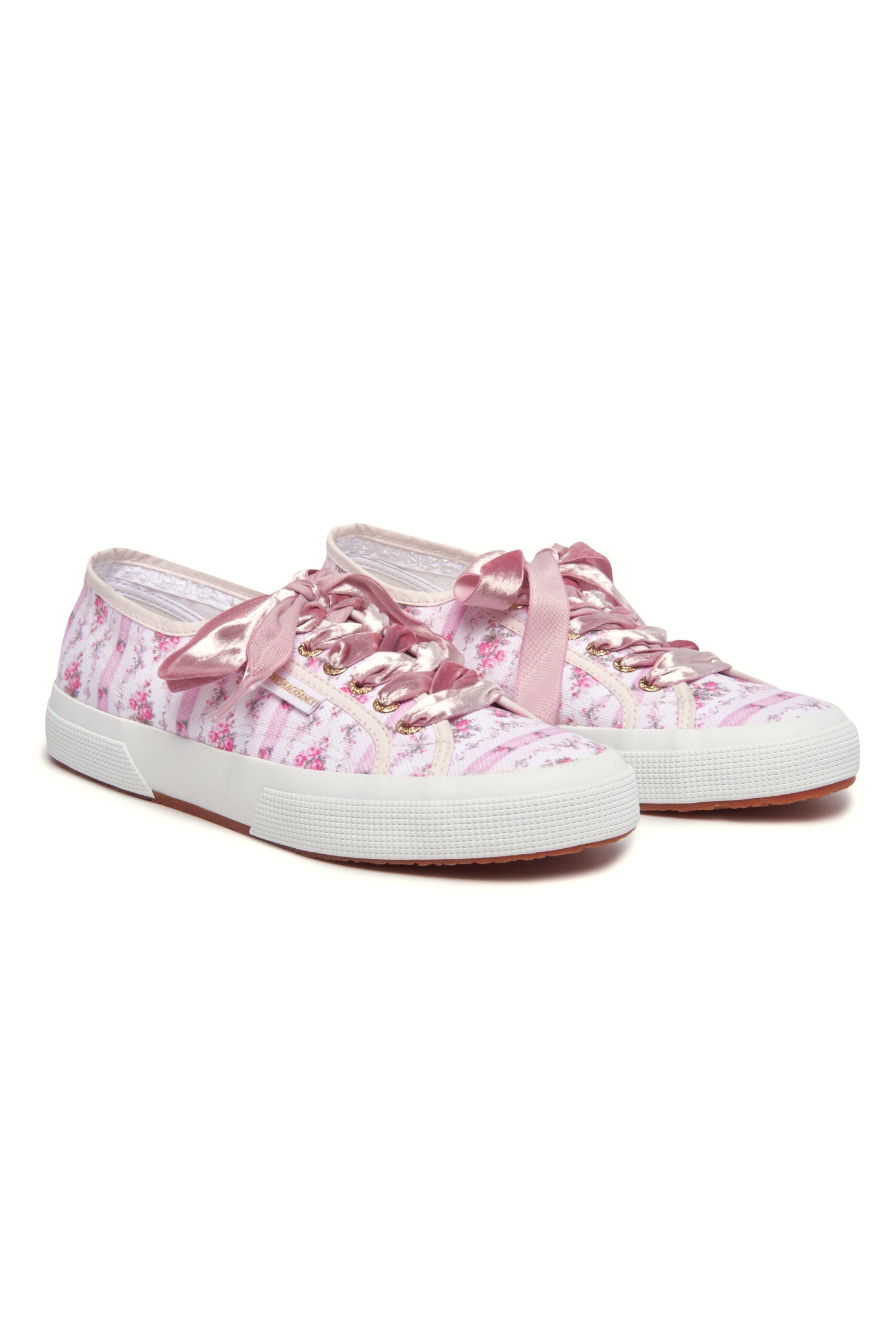 Pastel pink sneaker with floral pattern on printed cotton, gold-toned eyelet details, and pink velvet laces.