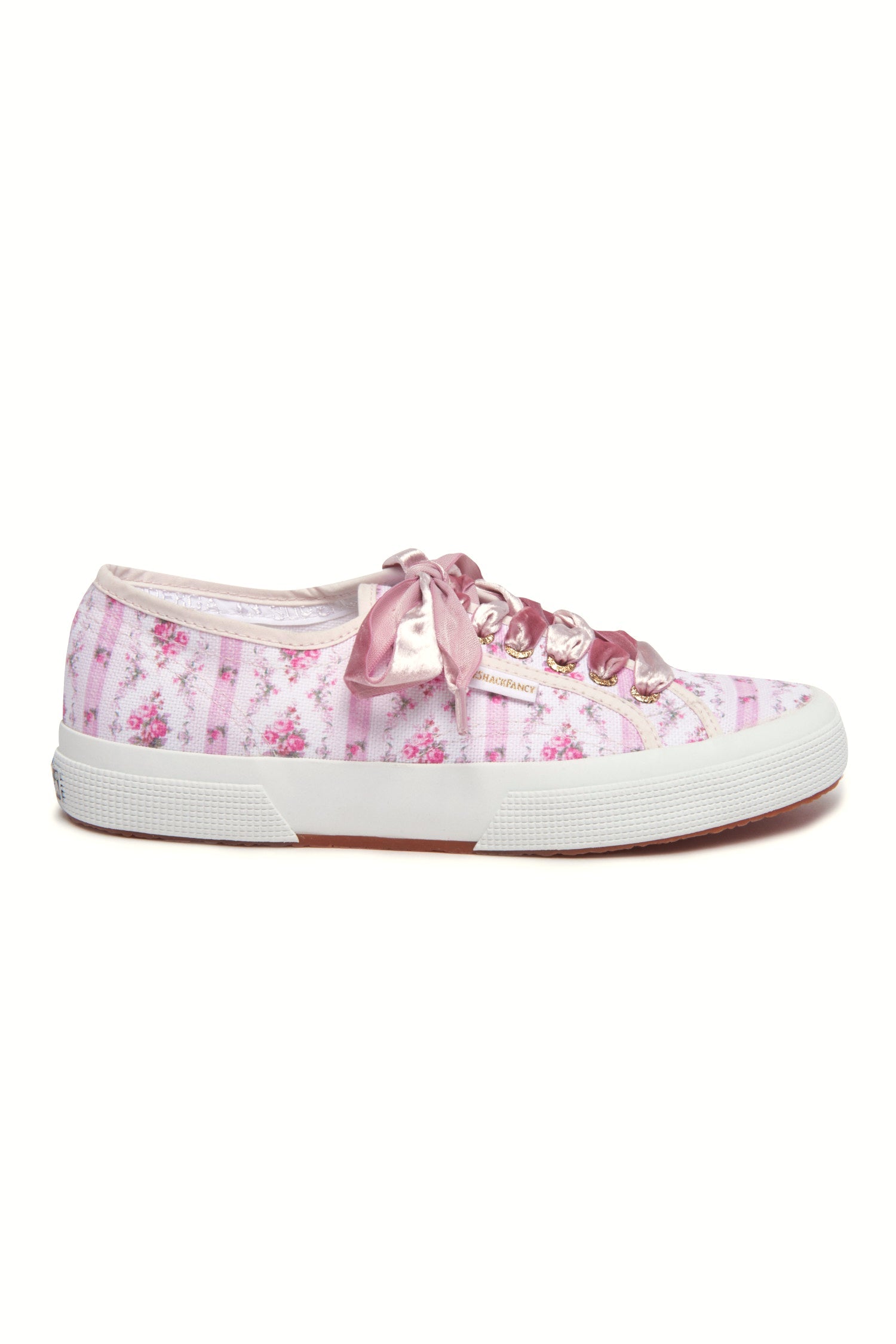 Pastel pink sneaker with floral pattern on printed cotton, gold-toned eyelet details, and pink velvet laces.