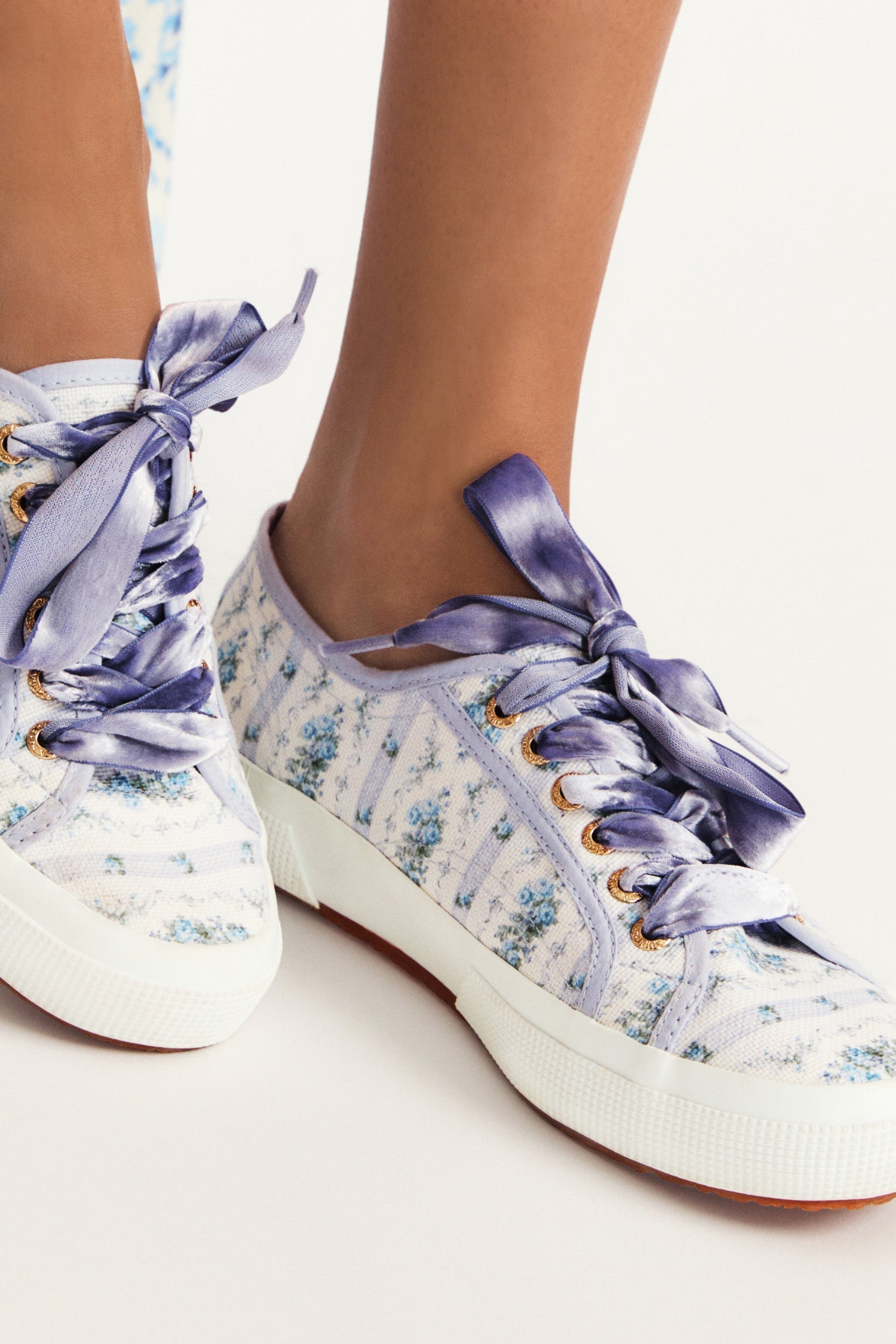 Pastel purple/lilac sneaker with floral pattern on printed cotton, gold-toned eyelet details, and purple velvet laces.