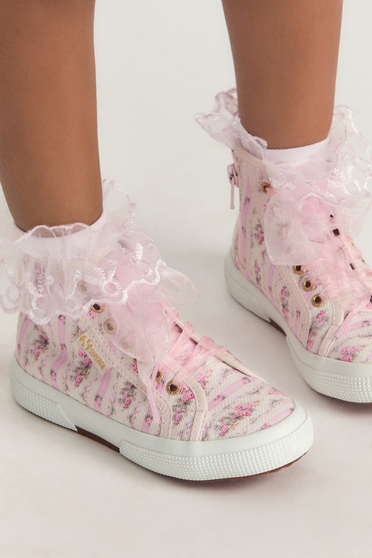 Pink hightop sneakers with florals on printed cotton with tulle laces, and gold-tone eyelet details.