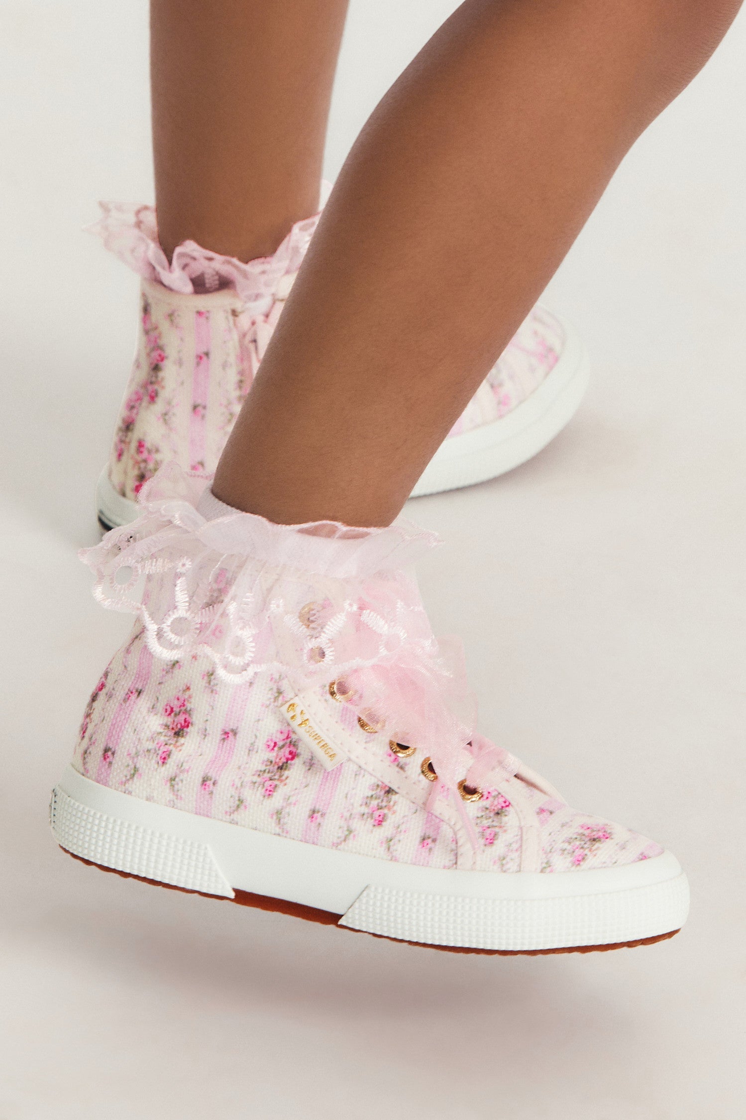 Pink hightop sneakers with florals on printed cotton with tulle laces, and gold-tone eyelet details.