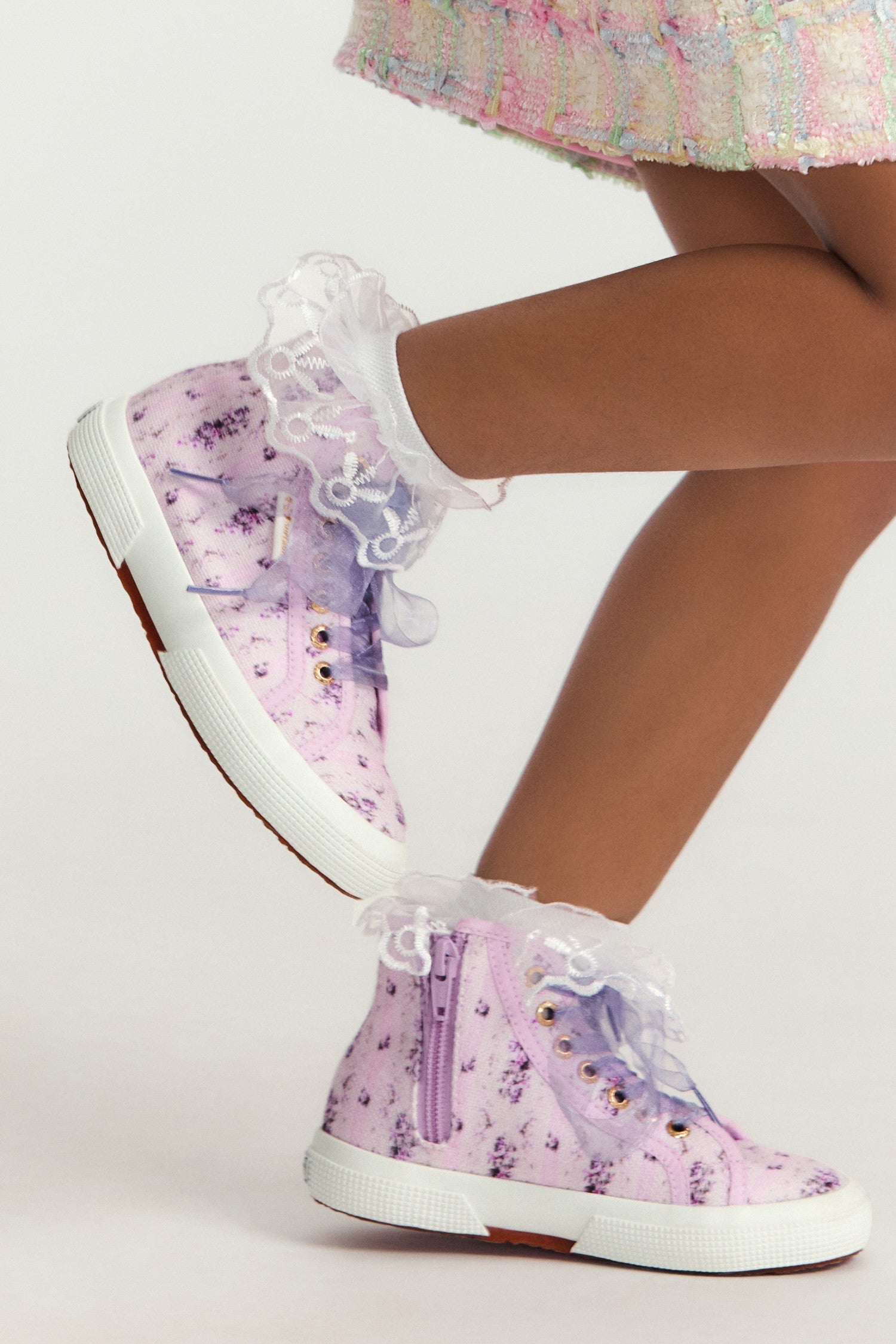 Pink and purple hightop sneakers with florals on printed cotton with tulle laces, and gold-tone eyelet details.